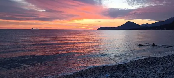 Kumsalda gün batımı, Karadağ kıyılarında gün batımı kırmızı renkler, sakin deniz, sakin hava