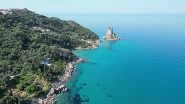Korfu Adası, Yunanistan 2023 Yazı. Yunanistan 'ın Korfu adasının birçok sahilinden birinin sahili, kristal berrak zümrüt deniz suyuyla inanılmaz görünüyor.