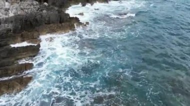 Akdeniz 'de dalgalar çarpıyor. Video bir dronun yardımıyla yapıldı, yavaş çekimde, dalgaların kayalara çarpmasını yukarıdan izlemek inanılmaz bir şey.