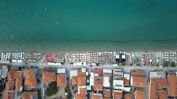 Yunanistan, Halkidiki. Bir sürü güneş şemsiyesi olan kalabalık bir plaj.