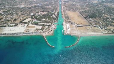 Bu hava manzarasında turkuaz sularda bir marina var. Etrafı sükuneti çağrıştıran manzarayla çevrili.