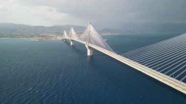 Aşağıdaki dalgalı suyla kıyıları birbirine bağlayan nefes kesici asma köprü, seyahat ve mimari temalar için ideal.