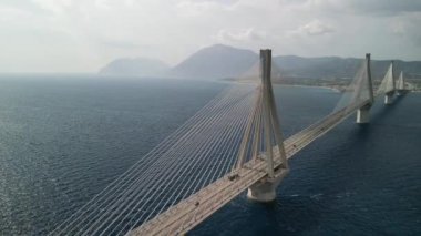 Aşağıdaki dalgalı suyla kıyıları birbirine bağlayan nefes kesici asma köprü, seyahat ve mimari temalar için ideal.
