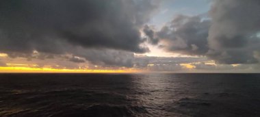 Geniş ve geniş bir su kütlesi, arka planda beliren bulutlu bir gökyüzü eşliğinde büyüleyici bir doğa güzelliği manzarası yaratıyor.