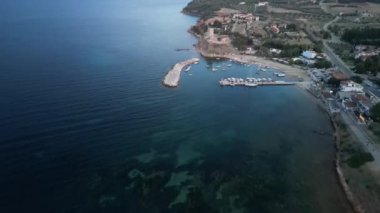 Hava manzarası, büyüleyici bir kulesi ve deniz kenarında kumlu güzel bir sahili olan pitoresk bir kıyı köyünü gösteriyor.
