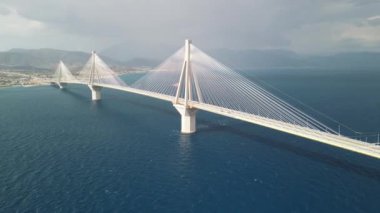 Dramatik gökyüzünün altında sakin mavi sulara uzanan uzun bir köprünün nefes kesici perspektifi..