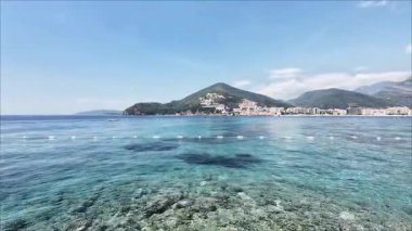 Mavi gökyüzü ve büyüleyici dağlara karşı şeffaf deniz. Yüksek kaliteli FullHD görüntüler