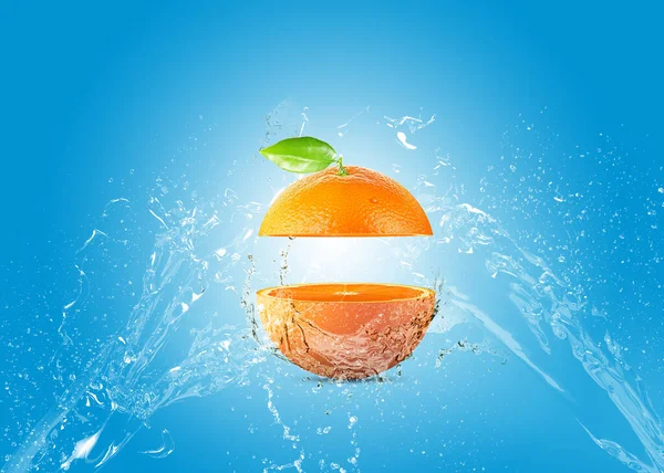Fresh Orange With Water Splash. Fresh slice orange on blue background. orange manipulation creative concept. Manipulation concept.