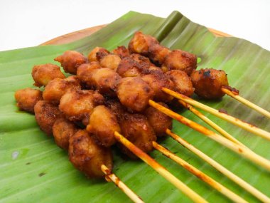 Beyaz arka planda izole edilmiş baharatlı sosla kaplı kızarmış köfteler.