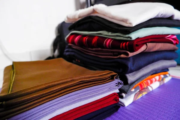 Stack of colorful clothes, Piles of clothes are already spread out on the purple carpet.