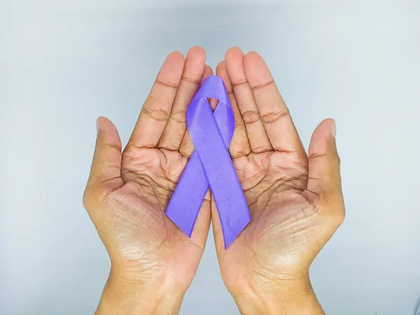 World Cancer Day, Hand holding Purple Ribbon prevention support for World Cancer Day, isolated on a white background, Healthcare and medical concept.