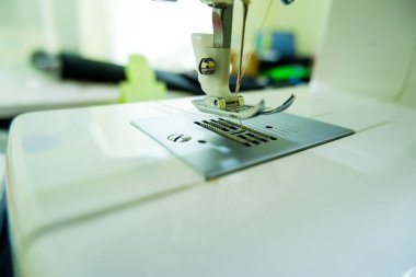 Dikiş makinesi arkaplanı bulanık ya da odaksız.