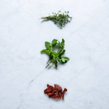 Aromatik aromalı, İtalya 'dan izole edilmiş mermer arkaplan kurutulmuş domatesler, Kereste Dalları, Taş Mutfak Masasında İkizlerle sarılı Nane, Yüksek Çözünürlüklü Makro, Üst Görüş