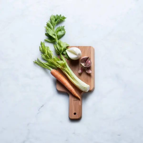 木制切菜板上的蔬菜 在大理石背景上分离的全麦胡萝卜 白皮洋葱和紫色皮肤特大号 顶部视图 — 图库照片