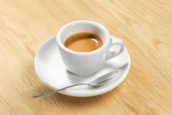 İtalyan Espresso Kahve Kupası ahşap masanın üstünde. Geleneksel Beyaz Mermer Kupa 'da orijinal kremalı kahve. Spoon, Cream üzerine odaklan.