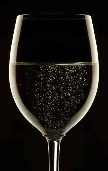 Glass of sparkling wine on black background