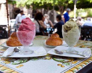 Dondurma bardağında soğuk Sicilya granitası Brioche ile çilekli granita ve kafede brioche soslu Pistachio granita.