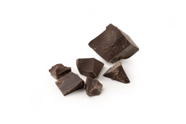 Beyaz arka planda siyah çikolata parçaları. Parçalar şekil ve boyut olarak düzensiz.