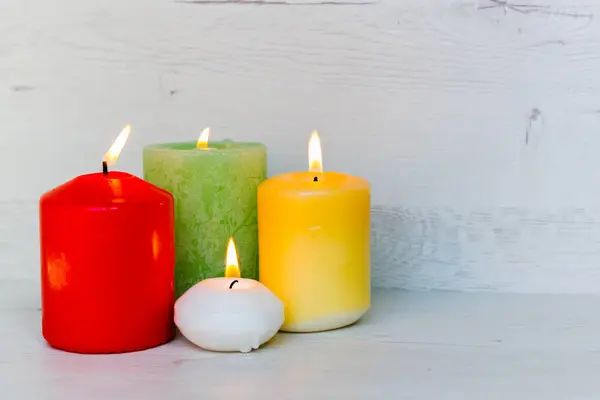 Açık ahşap arkaplanda farklı renklerde mum yakmak