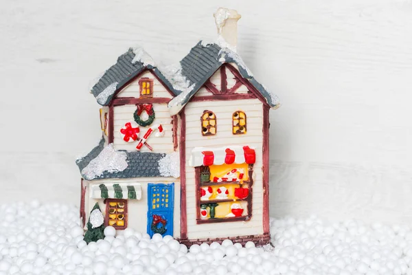 Hafif arka planda kar taneleriyle çevrili bir Noel evi.