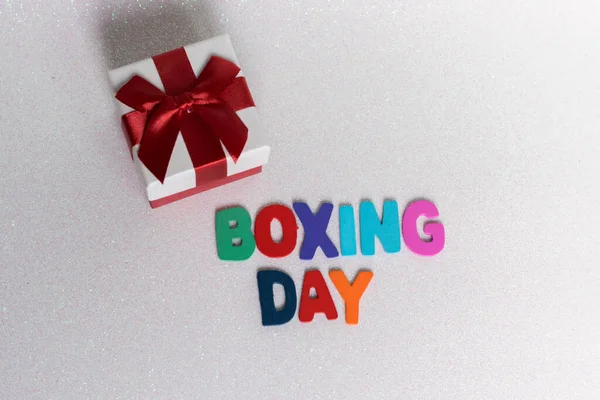 colorful letters with the phrase Boxing Day and a gift box on a light background