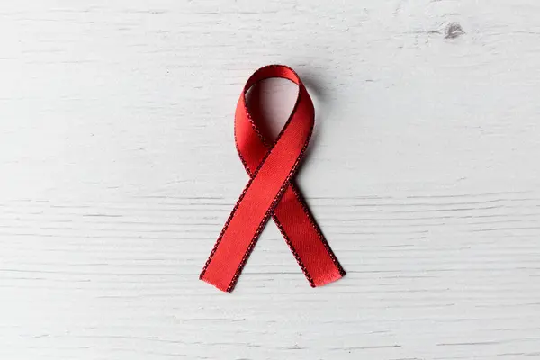 AİDS hastalarını destekleyen kırmızı kurdele açık ahşap arka plan ve çalışma alanı