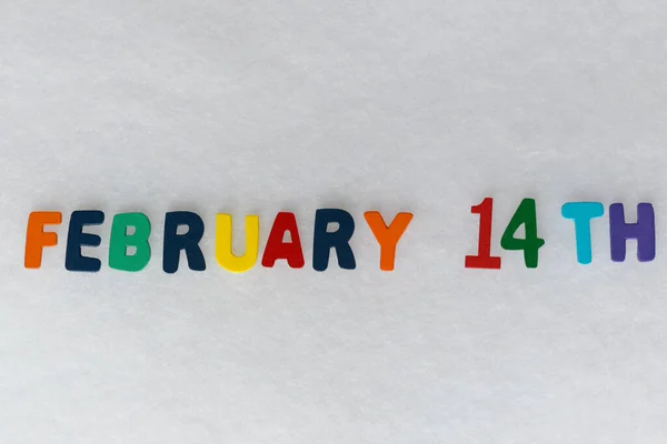 Beyaz arkaplan ve çalışma alanı üzerinde 14 Şubat tarihli renkli harfler