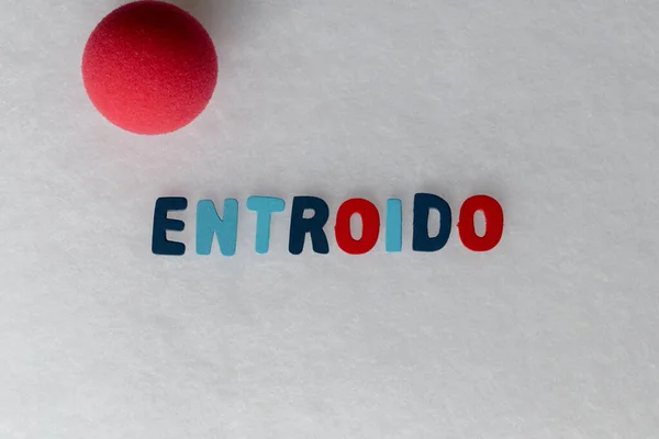 Galiçya dilinde Entroido kelimesinin olduğu renkli harfler ve çalışmak için beyaz bir arka plan ve alanda dekoratif palyaço burnu.