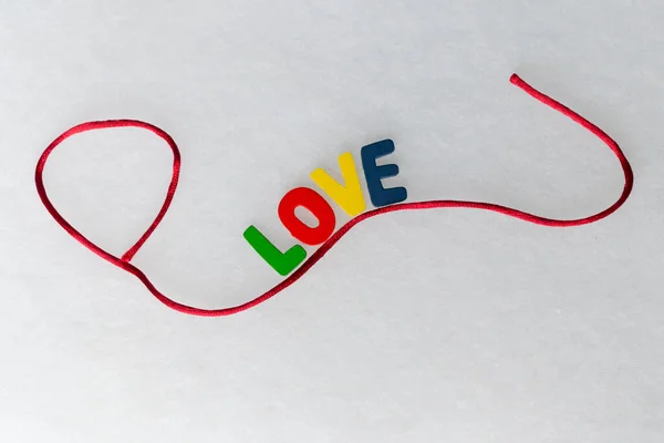 Beyaz arkaplanda aşk sözcüğü ve kırmızı dantel süslemeli renkli harfler ve çalışma Icono de Validado por la comunidad