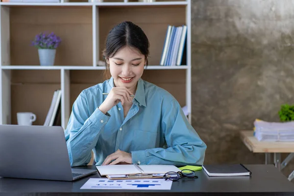 ラップトップコンピュータを使用してオフィスで働くアジアの女性 オフィスの財務報告書のテーブル計画分析の計算機の財務文書 — ストック写真