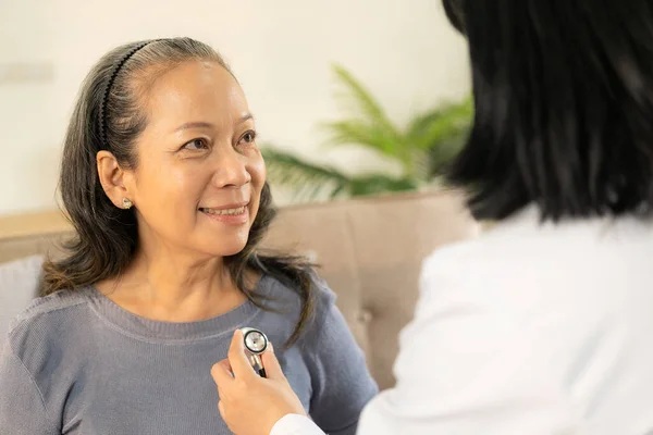 Medico Esaminando Cuore Con Stetoscopio Parlando Con Donna Anziana Clinica — Foto Stock