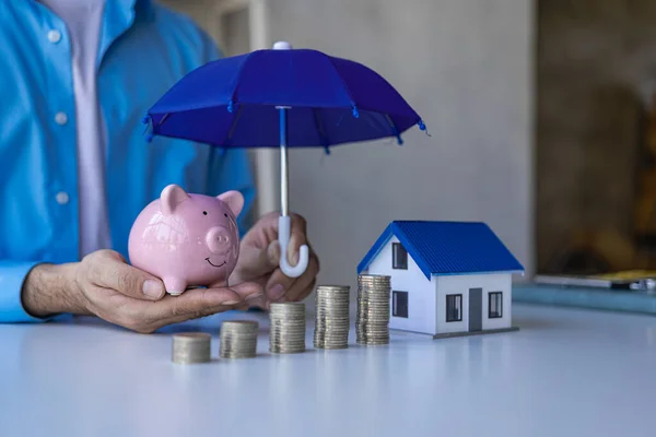 concept of insurance and health, family and property, man holding umbrella on Insurance agents present toys that symbolize protection.