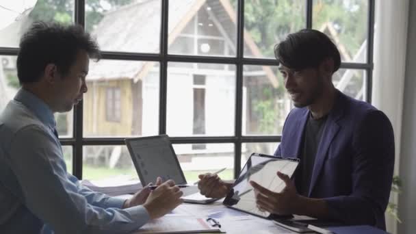 Двоє Молодих Азіатських Бізнесменів Костюмах Обговорюють Дані Фінансового Ринку Офісі — стокове відео