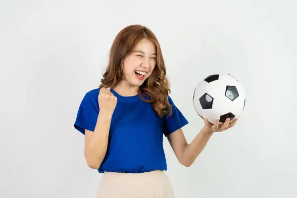 幸せなアジアの女性サッカーファンがサッカーボールで好きなチームにサポートを送信し 青いTシャツの笑顔の女性がサッカーボールを保持し 白い背景で孤立しました — ストック写真