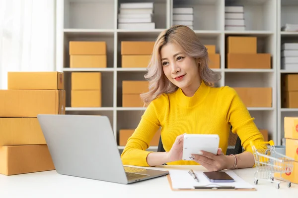 美しい若いアジアの女性は 自宅でオンライン注文を取るラップトップとオンライン販売ボックスで働いています Smeビジネスコンセプト — ストック写真