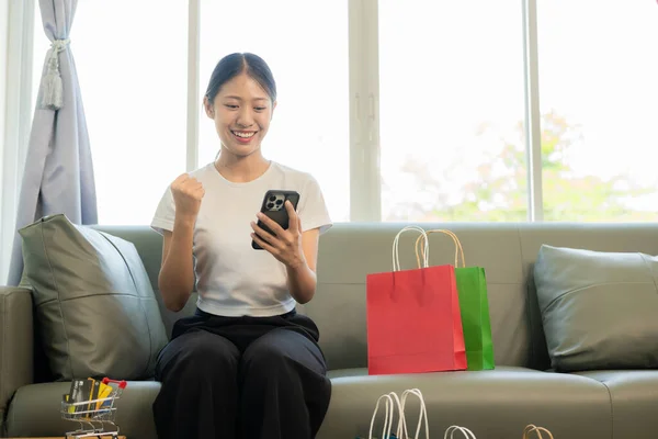 Mulher Asiática Segurando Cartão Crédito Telefone Inteligente Laptop Sentado Sofá — Fotografia de Stock