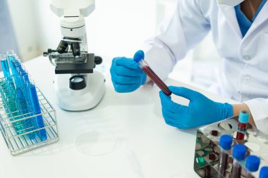 Kimya laboratuvarında ilaç araştırması, mikroskopla çalışan kimya bilimcisi, deney tüpleri kullanarak sıvı testlerini analiz eden tıbbi laboratuvar konsepti.