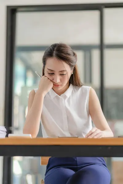 在现代办公室里 穿着衬衫与笔记本电脑一起工作的令人困惑的亚洲女性高管做笔记 并提出一个专业的计划 考虑金融业务的概念 — 图库照片