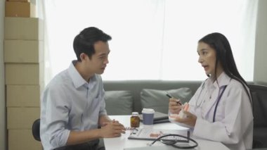 Beyaz laboratuvar önlüğü ve sınav eldivenleriyle gülümseyen güzel kadın dişçi, diş aletleri kullanıyor ve diş sağlığı kliniğinde diş modeli olan genç erkek hastayı muayene etmeye başlıyor..