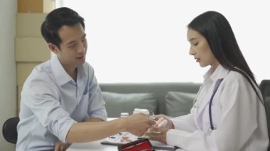 Beyaz laboratuvar önlüğü ve sınav eldivenleriyle gülümseyen güzel kadın dişçi, diş aletleri kullanıyor ve diş sağlığı kliniğinde diş modeli olan genç erkek hastayı muayene etmeye başlıyor..