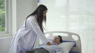 Asyalı kadın doktor, bir hastane yatağında suni teneffüs yaparak kalp krizi geçiren bir hastaya ilk yardım yapıyor. Doktor ilk yardım için göğsüne bir el pompası kullanır. Kalp masajı tıbbi konsepti