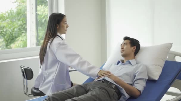 Asiatische Psychiaterin Berät Einen Männlichen Patienten Und Schreibt Krankenhausbett Symptome — Stockvideo