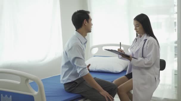 Asijské Psychiatrička Poradenství Mužského Pacienta Psaní Příznaků Notebooku Nemocničním Lůžku — Stock video