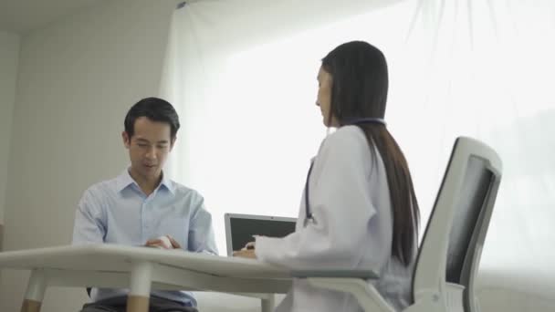Joven Médico Asiático Uniforme Médico Blanco Utiliza Portapapeles Para Discutir — Vídeo de stock