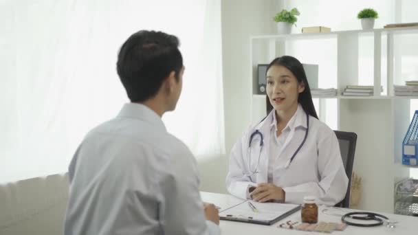 Joven Médico Asiático Uniforme Médico Blanco Utiliza Portapapeles Para Discutir — Vídeos de Stock