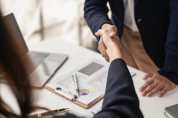 Молодые бизнесмены пожимают руки после успешной сделки, работают вместе и работают вместе, чтобы начать новый бизнес. Крупный план.