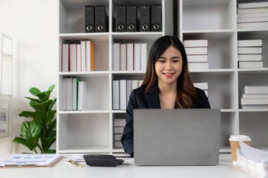 İş yerinde dizüstü bilgisayar ve analiz grafikleriyle çalışan Asyalı iş kadını, iş finans ve mali rapor, iş planı yatırımı,