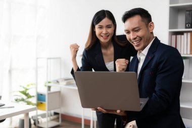 İki Asyalı işadamı laptoplarla kutluyor Başarılı Ticaret Hareketi Bilgisayardan iyi haberler alıyor İnternet teknolojisi, finans dünyası konsepti