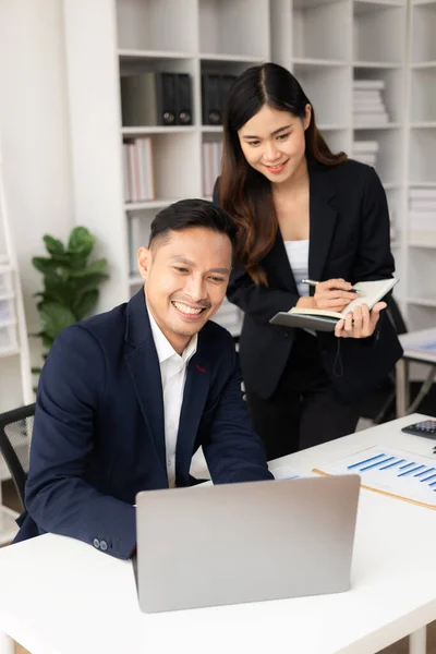 两名亚洲男女商人带着笔记本电脑和财务文件愉快地微笑着 他们谈论自己的项目 在办公室里集思广益 集思广益 集思广益 — 图库照片