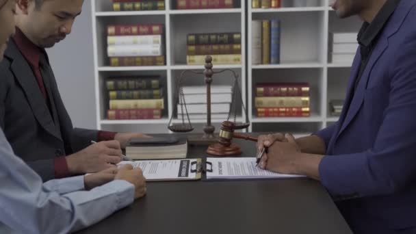 法律事務所のテーブルに真鍮のスケールを持つ弁護士弁護士 男性弁護士とビジネスクライアント税と法律事務所の弁護士の間の協議 — ストック動画